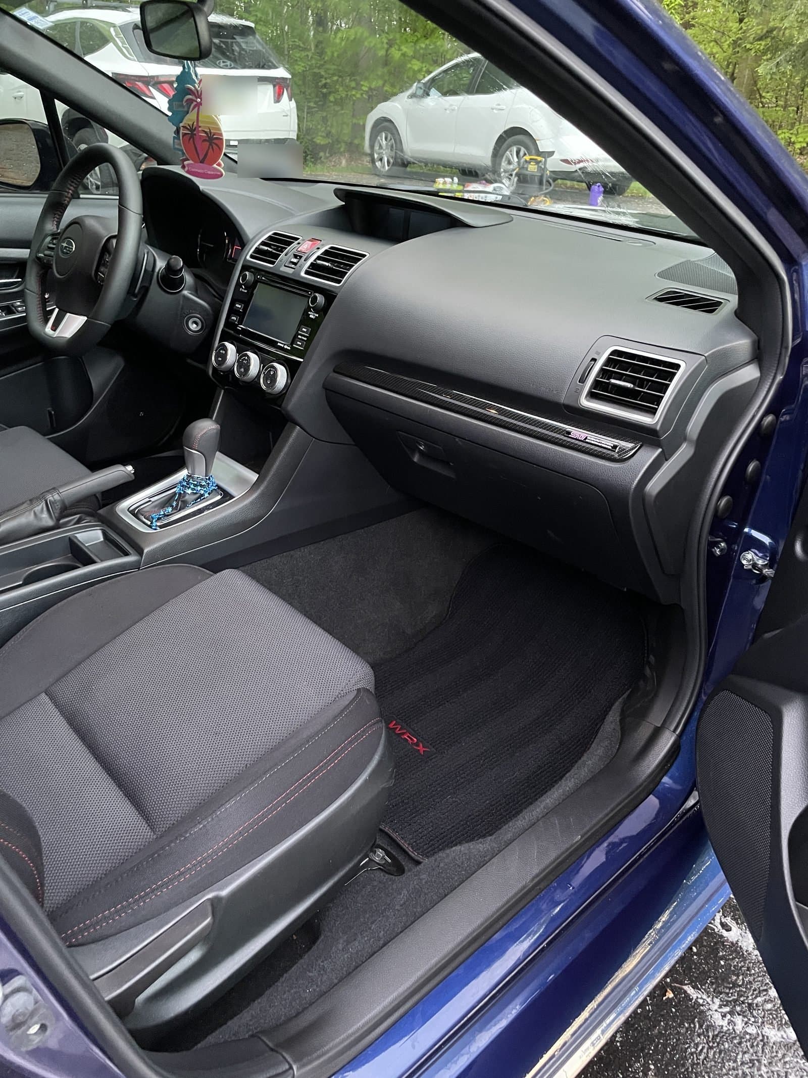 Clean interior of a blue Subaru WRX showing the dash and front seats