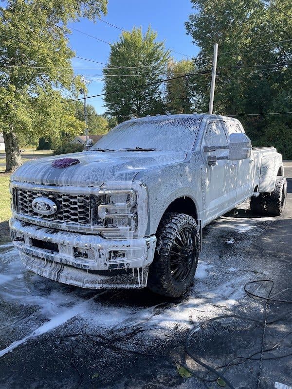 Ford Super Duty pickup covered in cleaning foam during a wash