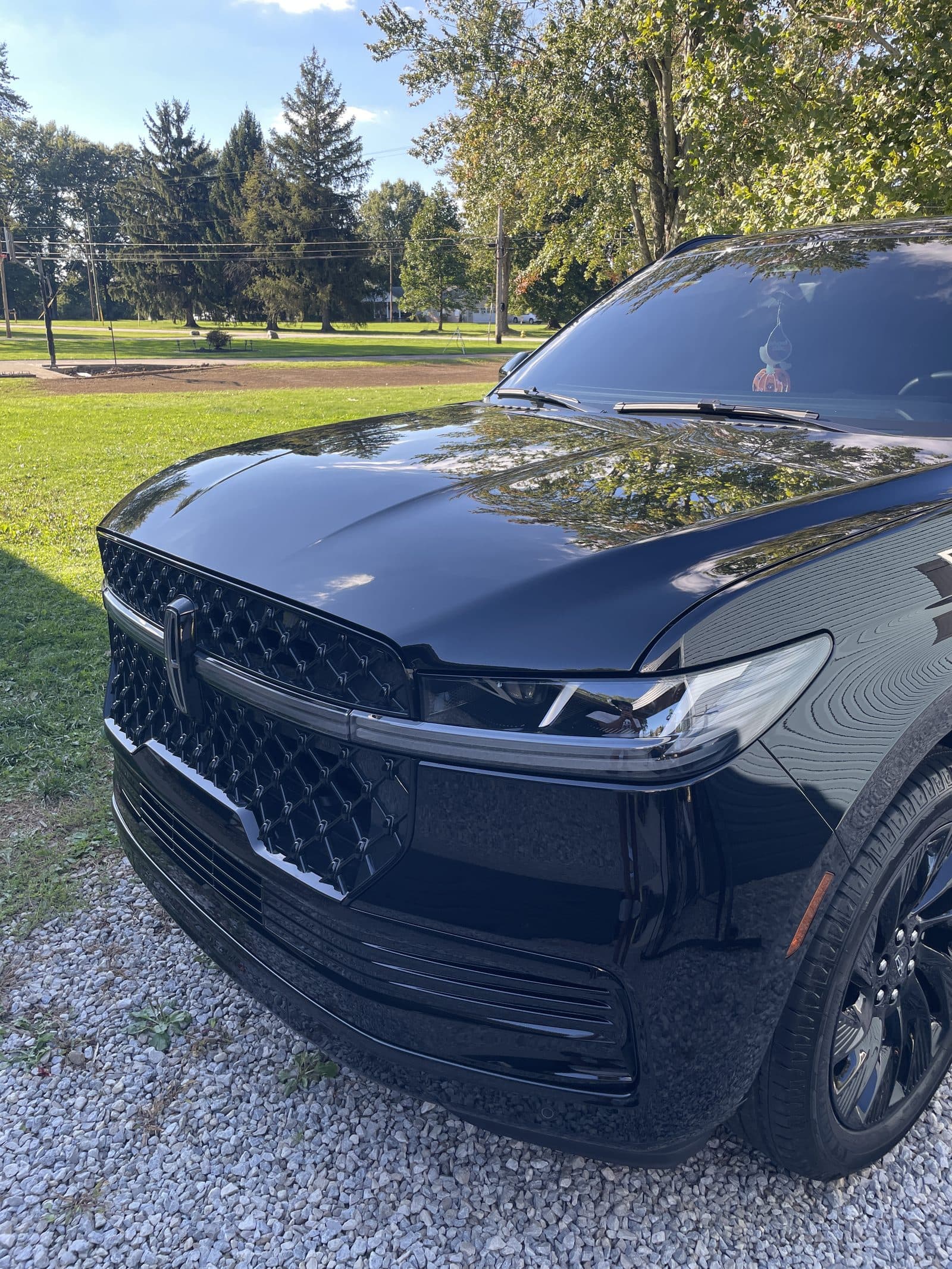 Front grille and glossy hood of a black Lincoln Navigator after detailing