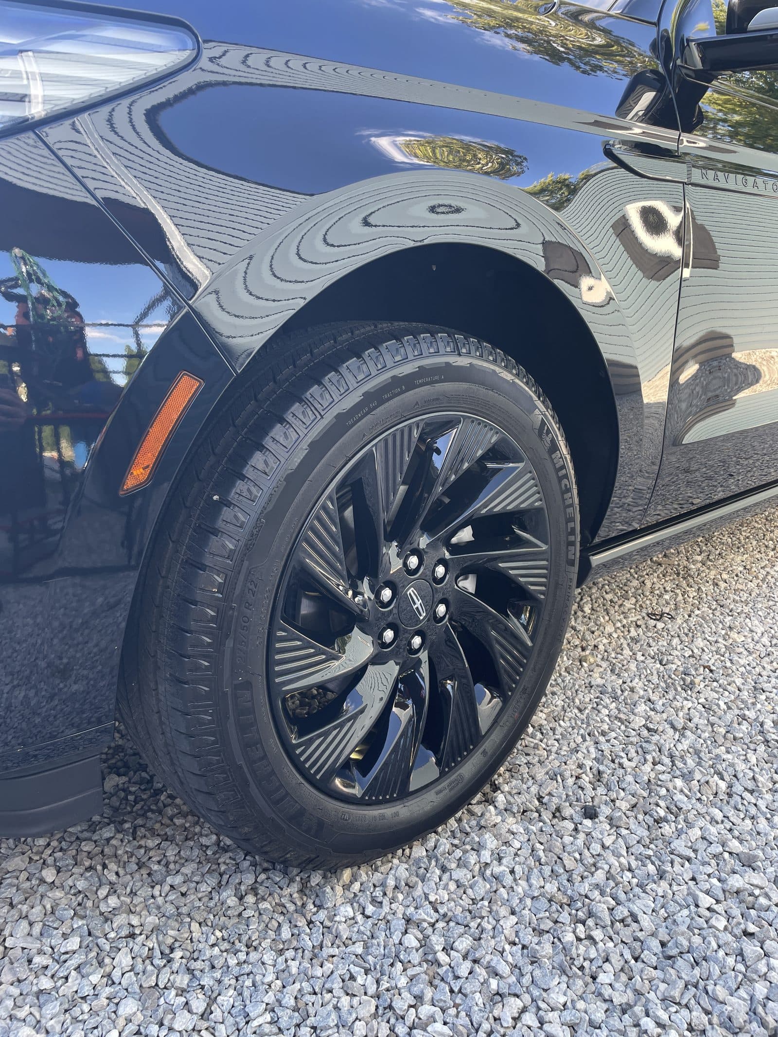 Gloss-black wheel and front fender of a Lincoln Navigator after detailing