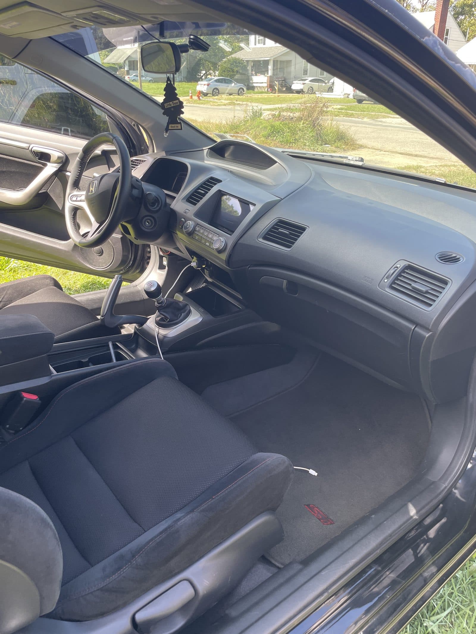 Clean Honda Civic interior showing the dash, shifter and front seat after detailing