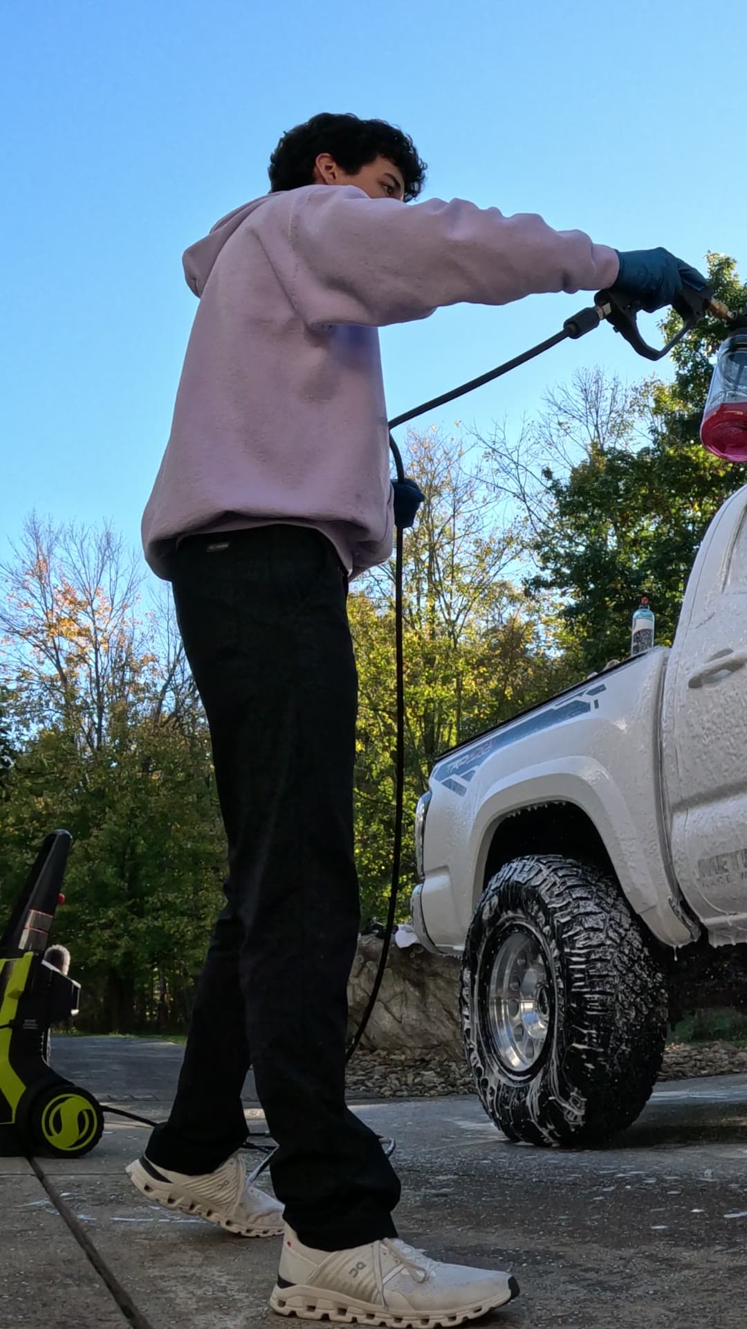 Shane foaming a white Toyota Tacoma in a driveway